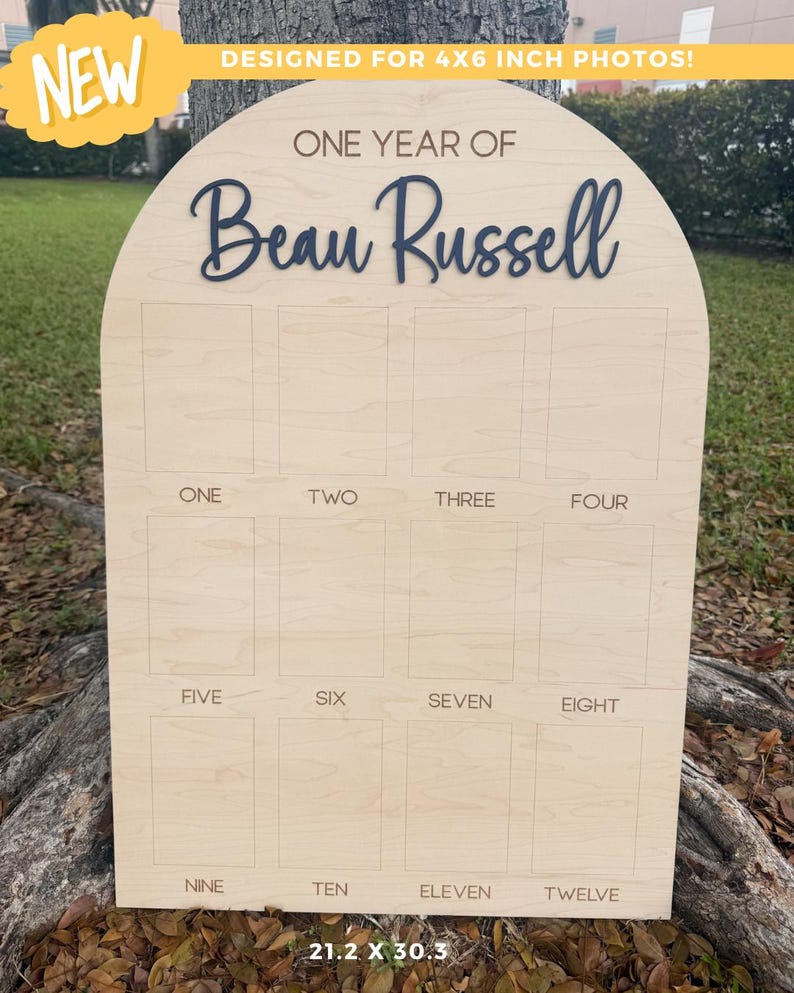 Wooden arch photo board with the text "ONE YEAR OF Beau Russell" in a dark blue font. The board has 12 photo slots labeled "ONE" through "TWELVE". The board is 21.2 x 30.3 inches.  This birthday boar is for 4x6' photos.