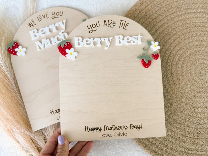 May include: Two wooden plaques with arched tops. One says "We love you Berry Much" and the other says "You are the Berry Best". Both have strawberry and flower embellishments. The bottom of the plaques say "Happy Mother's Day! Love, Olivia".