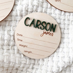 Wooden birth announcement disc personalized with baby's name in green 3D letters and script. Laser engraved stats tittles.