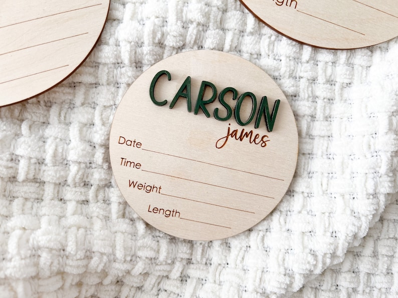 Wooden birth announcement disc personalized with baby's name in green 3D letters and script. Laser engraved stats tittles.