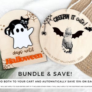 K&ouml;nnte beinhalten: Zwei Halloween-Schilder aus Holz. Eines zeigt eine schwarze Katze auf einem wei&szlig;en Geist mit dem Text "days until Halloween". Das andere hat ein Fu&szlig;abdruck-Design mit Fledermausfl&uuml;geln und dem Text "CREEPIN IT cute!" und "MICHAEL'S FIRST HALLOWEEN - 2025."