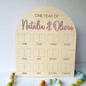 Wooden one year photo board with an arched top. This is a twins birthday photo board.  This milestones boar will required wallet size photos.