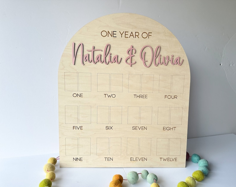 Wooden one year photo board with an arched top. This is a twins birthday photo board.  This milestones boar will required wallet size photos.