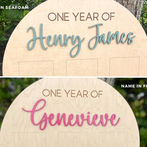 Wooden birthday photo board with the text "ONE YEAR OF" and a name in teal or fuchsia. Showing a close up of the arch with engrave One Year Of and the child's name in a variety of colors.
