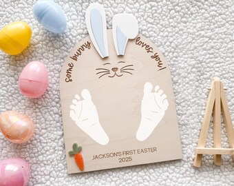 May include: A wooden bunny rabbit cutout with a space for baby footprints. The cutout has the text "Some bunny loves you!" and "JACKSON'S FIRST EASTER 2025".