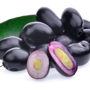 May include: A cluster of dark purple, oval-shaped jamun fruits with smooth, shiny skin. Two green leaves are visible behind the fruit. One fruit is sliced in half, revealing a light green seed surrounded by a vibrant purple, juicy flesh.