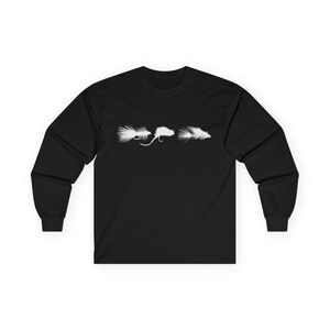 May include: Black long-sleeve shirt featuring three white fly fishing lures. The lures are arranged horizontally across the chest. The shirt is made of a soft, comfortable material, suitable for casual wear or outdoor activities.