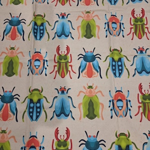 May include: A light beige fabric featuring a repeating pattern of stylized beetles in vibrant shades of blue, green, red, and peach. The insects are arranged in a grid, showcasing various shapes and colors, including stag beetles and spotted varieties.