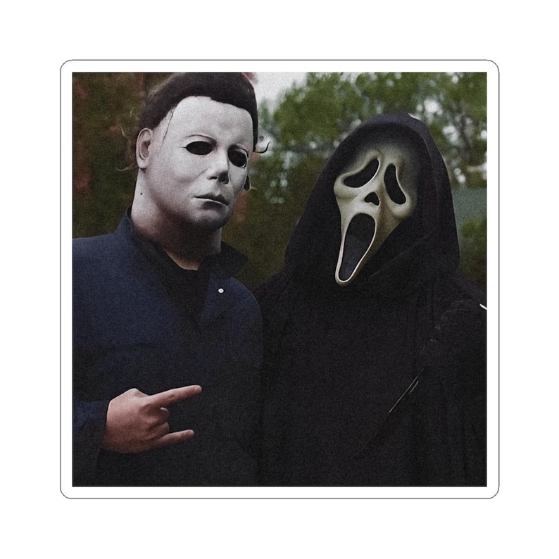 May include: A sticker featuring two figures: one wearing a white, expressionless mask with dark hair and a dark blue collared shirt, and the other wearing a black hooded robe with a pale, elongated ghost mask with a wide, open mouth expression.
