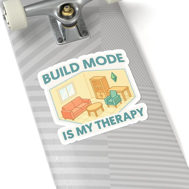 May include: A sticker with a cartoon image of a room with furniture, including a sofa, armchair, and table. The text "BUILD MODE IS MY THERAPY" is displayed in a white font with a blue outline.