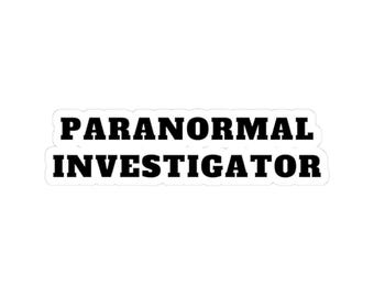 Könnte beinhalten: Ein gestanzter Aufkleber mit dem Text PARANORMAL INVESTIGATOR in fetten, schwarzen Serifenschrift-Großbuchstaben. Das Design ist zweizeilig angeordnet und von einem weißen Rand umgeben, der dem Textverlauf folgt, was eine klare Optik ergibt.