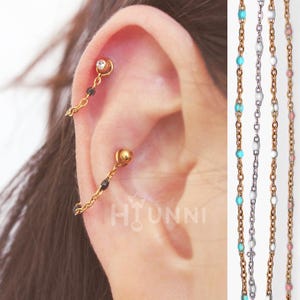 Pendiente de aro con forma de caracola, hecho a mano, con cuentas de 20 g y 16 g, acero quirúrgico 316L, color negro, ópalo y blanco. Se vende por unidad.