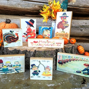 May include: A set of eight wooden blocks with vintage Thanksgiving-themed illustrations. The blocks feature images of turkeys, pilgrims, and pumpkins, with text such as "Happy Thanksgiving" and "Eat More Pie!"
