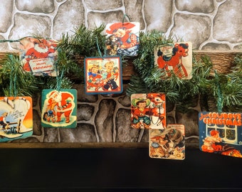 May include: Nine vintage Christmas ornaments featuring cowboys, Santa Claus, and a reindeer. The ornaments are square and have a blue and red color scheme. The ornaments are hanging on a green garland.