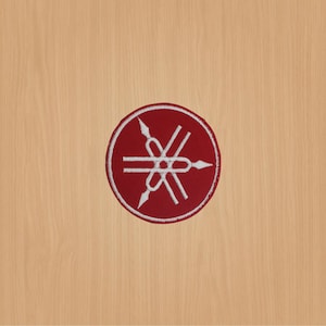 Op de afbeelding: Een rode ronde patch met een wit Yamaha-stemvorklogo.