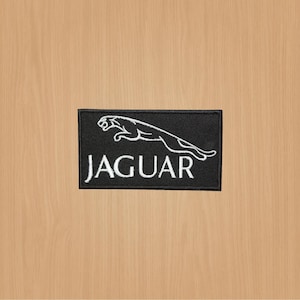 May include: Black and white embroidered patch with a leaping jaguar silhouette and the word "JAGUAR" in white lettering.