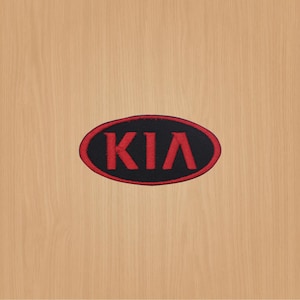 Peut inclure: Logo KIA brodé en rouge sur un patch ovale noir.