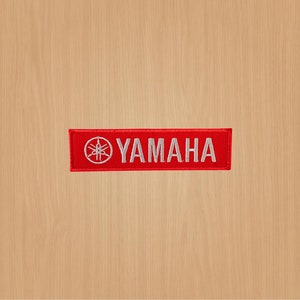 May include: Red embroidered patch with a white Yamaha logo and tuning fork symbol.