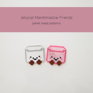 May include: Two square perler bead patterns labelled Jellycat Marshmallow Friends. One is white and one is pink, both featuring a smiling face with black eyes, a black mouth, and small brown feet at the bottom corners, arranged on a plain surface.