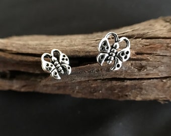 Op de afbeelding: Een paar zilveren oorbellen in de vorm van vlinders. De vlinders zijn gedetailleerd en hebben een delicaat ontwerp.