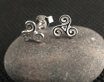 May include: A pair of silver stud earrings featuring a Celtic knot design. The earrings are small and delicate, and they would make a great gift for someone who loves Celtic jewelry.