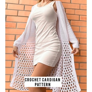 May include: White crochet cardigan pattern. The cardigan is a long, open-front style with a delicate, lacy design. It is shown being worn over a white tank top and a white skirt.