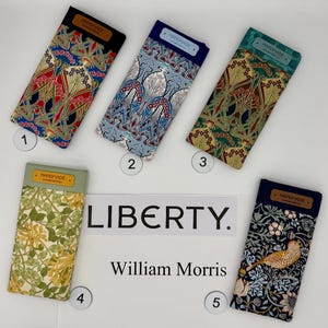 May include: Five fabric eyeglass cases with colorful floral and Art Nouveau patterns. Each case has a rectangular shape with a dark-colored top flap labeled "HANDMADE". The cases are numbered 1 through 5.
