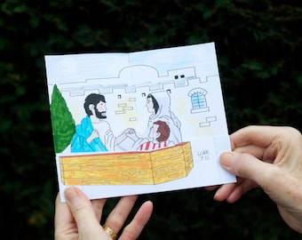 May include: A colorful illustration depicting a biblical scene with figures in robes, a person in a wooden box, and text that reads "Luke 7:11". The artwork is held by a person's hands against a blurred green background.