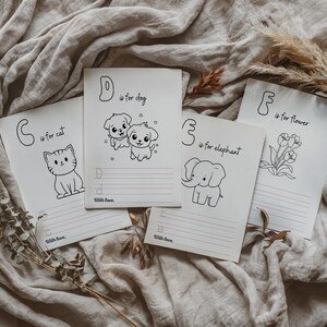 May include: Four black and white printable alphabet flashcards with illustrations of a cat, dog, elephant, and flower. Each card has a letter, the word for the image, and lines for writing.