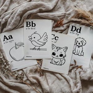 May include: Four black and white flashcards with the letters A, B, C, and D. Each card has a simple illustration of an apple, bird, cat, and dog, with the text "Aa is for apple", "Bb is for bird", "Cc is for cat", and "Dd is for dog".