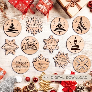 May include: A collection of twelve wooden Christmas ornaments featuring laser-cut designs including snowflakes, stylised trees, and text reading Merry Christmas or Let It Snow, arranged with gift boxes and holiday decorations.
