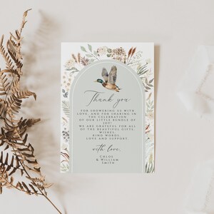 May include: A light blue thank you card with a watercolor illustration of a duck flying through an archway of greenery. The text reads "Thank you for showering us with love and for sharing in the celebration of our little bundle of joy. We are grateful for all of the beautiful gifts, kind words, love and support. With love, Chloe & William Smith."
