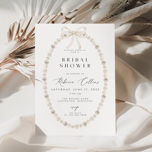May include: A white card with a pearl necklace design and the text "PLEASE JOIN US FOR A BRIDAL SHOWER IN HONOR OF Rebecca Collins SATURDAY, JUNE 11, 2022 1:00 PM THE ROUND BARN LEXINGTON, KENTUCKY RSVP TO JULIE AT 123-456-7890"