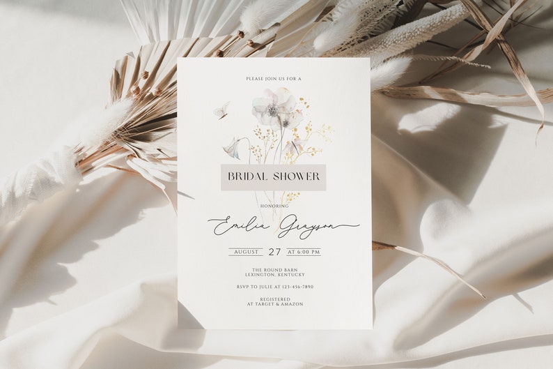 Puede incluir: Una tarjeta blanca con un dise&ntilde;o floral de acuarela y el texto "PLEASE JOIN US FOR A BRIDAL SHOWER HONORING Emilie Gueyon AUGUST 27 AT 6:00 PM THE ROUND BARN LEXINGTON KENTUCKY RSVP TO JULIE AT 121-416-2890 REGISTERED AT TARGET & AMAZON"