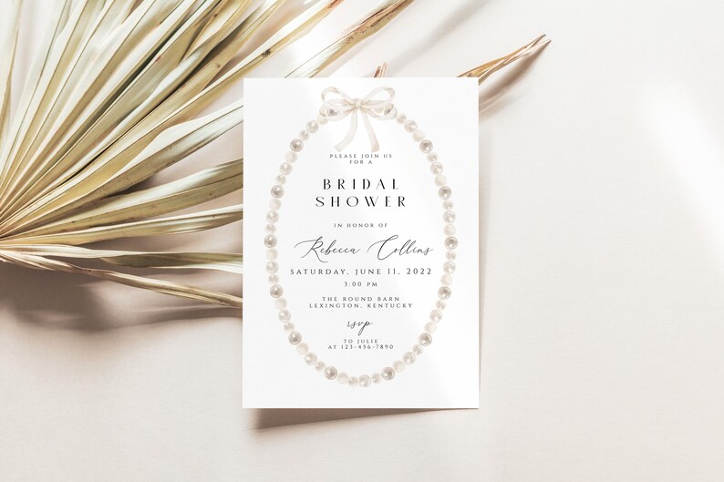 May include: A white bridal shower invitation featuring a pearl necklace design and the text "Please join us for a Bridal Shower in honour of Rebecca Collins Saturday, June 11, 2022 1:00 PM The Round Barn Lexington, Kentucky RSVP at 123-456-7890"