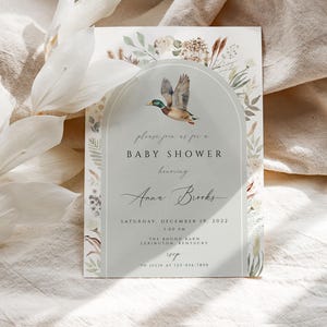 May include: A baby shower invitation with a watercolor illustration of a duck flying through an archway of greenery. The text reads "Please join us for a Baby Shower honoring Anna Brooks Saturday, December 19, 2022 1:00 PM The Round Barn Lexington, Kentucky RSVP to Julie at 123-456-7890"