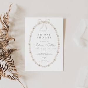 May include: A white bridal shower invitation featuring a pearl necklace design. The text reads "Please join us for a Bridal Shower in honour of Rebecca Collins, Saturday, June 11, 2022, 3:00 PM, The Round Barn, Lexington, Kentucky, RSVP by June 1, 2022 at [phone number]"