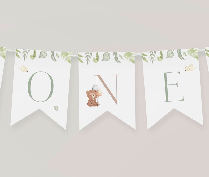 May include: A white banner with green leaves and a brown bear holding balloons. The banner spells out "ONE" in green letters.