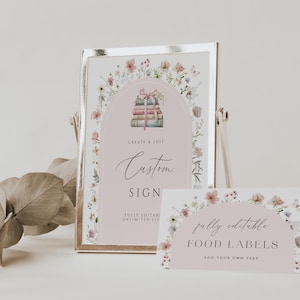 May include: A printable sign with a floral border and a stack of books with a pink ribbon. The sign says "Create & Edit Custom Sign Fully Editable Unlimited Use". A smaller sign with a floral border says "Fully Editable Food Labels Add Your Own Text".