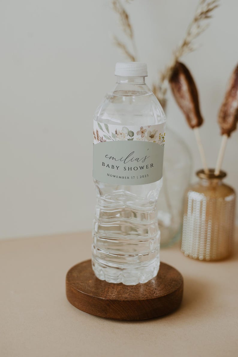 May include: A clear plastic water bottle with a green and white label that says "emilia's baby shower November 17, 2023".