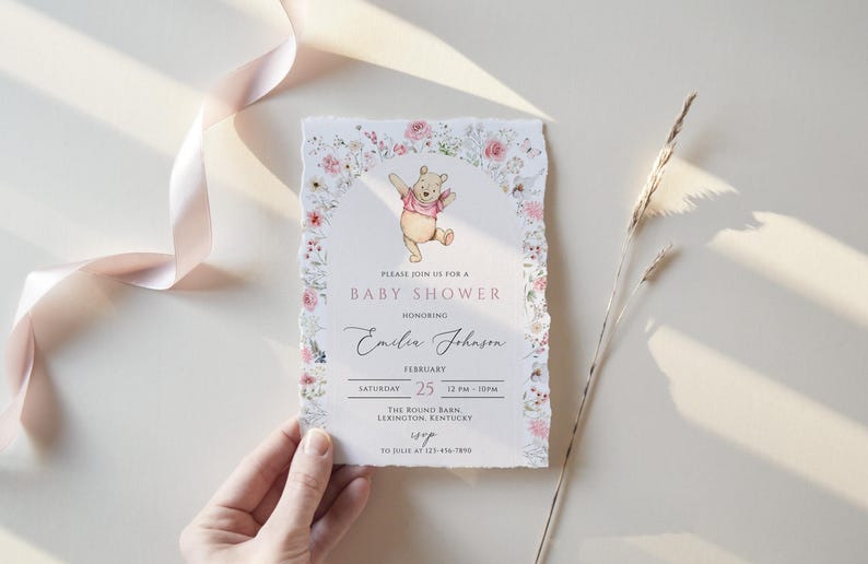 Pode incluir: Convite para ch&aacute; de beb&eacute; com uma ilustra&ccedil;&atilde;o de Winnie the Pooh e uma borda floral. O convite inclui o texto "PLEASE JOIN US FOR A BABY SHOWER" e o nome "Emilia Johnson". A data &eacute; 25 de fevereiro.