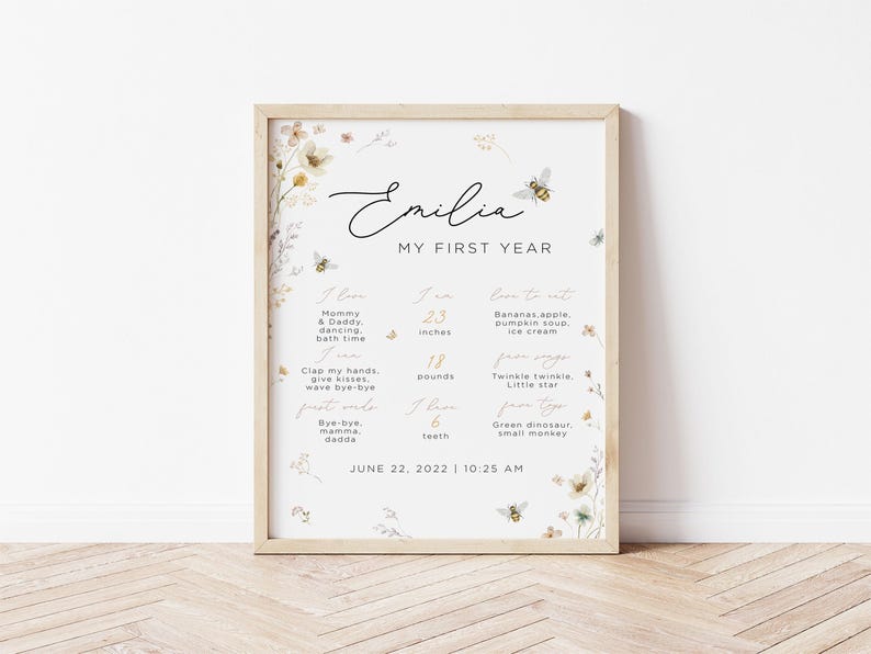 May include: A printable chart for a baby's first year milestones. The chart is decorated with floral illustrations and bees. It includes the baby's name, Emilia, and lists milestones such as height, weight, favorite foods, and first words. The chart is dated June 22, 2022, 10:25 AM.