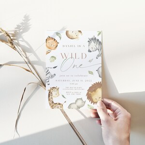 May include: A white invitation card with a watercolor illustration of jungle animals. The text reads "Daniel is a Wild One" and "Join us to celebrate Saturday, June 11, 2022".