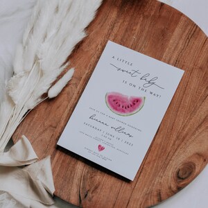 May include: A white baby shower invitation with a watermelon graphic and the text "A little sweet baby is on the way!"  Join us for a baby shower honoring [name] Saturday, June 10, 2023 at 1:00 PM. Allison's House, 1214 White Street, Lexington, Kentucky. Kindly RSVP to Allison at [phone number].