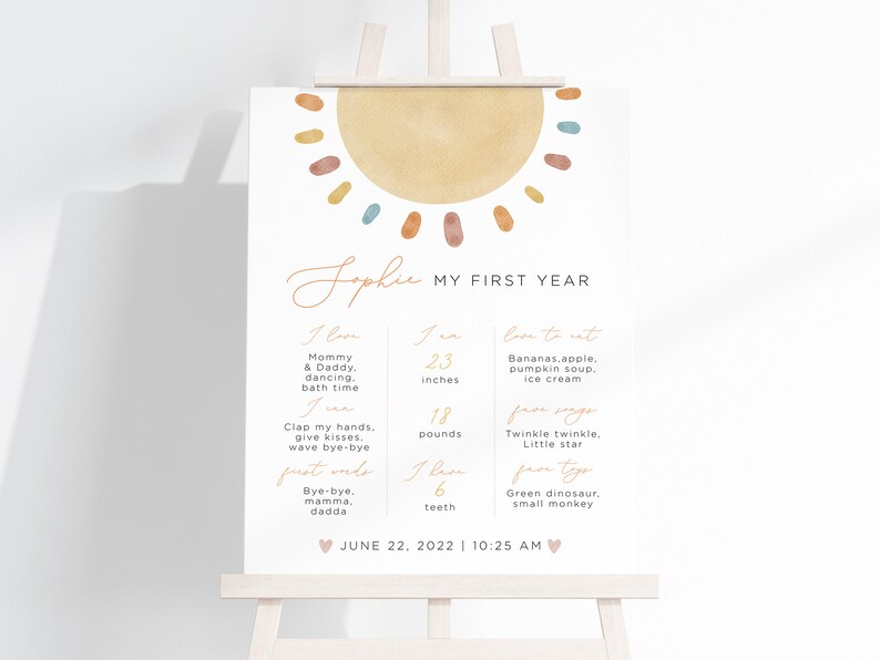 K&ouml;nnte beinhalten: Ein druckbarer Chart f&uuml;r die Meilensteine des ersten Lebensjahres eines Babys. Der Chart zeigt eine Aquarellsonne mit gelbem Hintergrund und bunten Punkten. Der Chart enth&auml;lt den Namen des Babys, Sophie, und listet Meilensteine wie Gr&ouml;&szlig;e, Gewicht und erste Worte auf. Der Chart enth&auml;lt auch ein Datum und eine Uhrzeit.