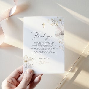Puede incluir: Una tarjeta de agradecimiento blanca con detalles florales y una cruz dorada. La tarjeta presenta una escritura elegante y el texto "Gracias" junto con un mensaje personalizado. La tarjeta est&aacute; dise&ntilde;ada para una ocasi&oacute;n especial.