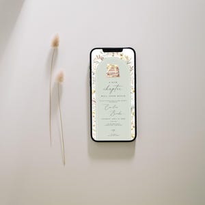 May include: A digital invitation on a smartphone screen with a green background and floral accents. The invitation reads "A new chapter will soon begin" with the names "Colin & Brooke" and a date. The invitation features a stack of books with a floral design.