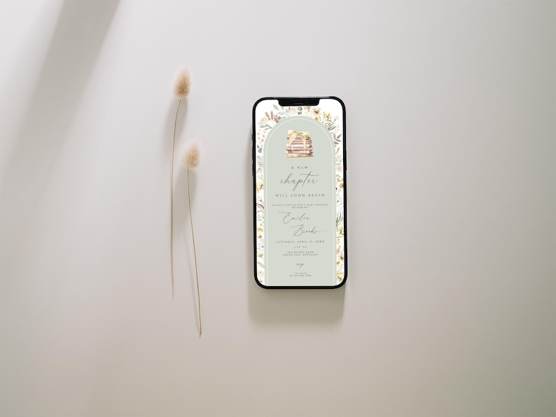 May include: A digital invitation on a smartphone screen with a green background and floral accents. The invitation reads "A new chapter will soon begin" with the names "Colin & Brooke" and a date. The invitation features a stack of books with a floral design.