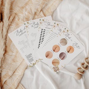 May include: Four printable baby shower game cards with floral designs. The games include a baby shower crossword puzzle, a guess the baby food game, a guess the mommy game, and a guess the baby's bottom game.