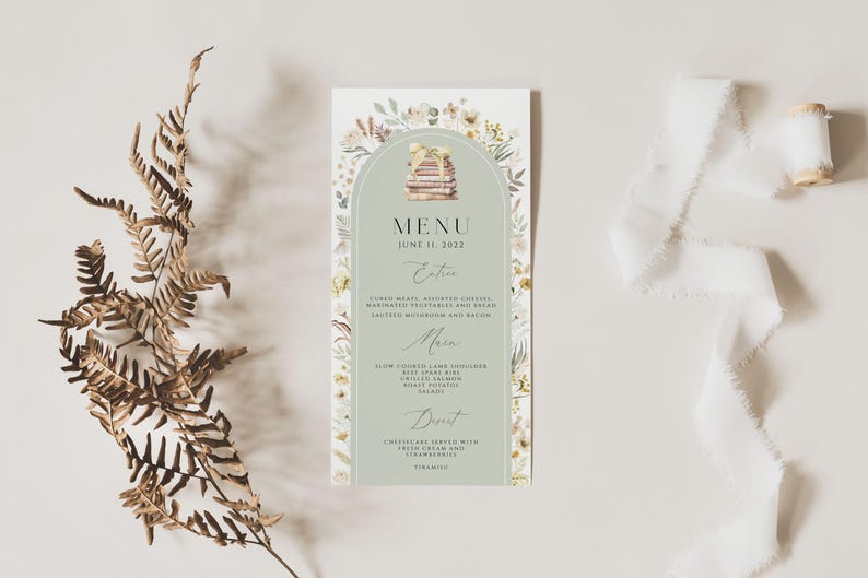 May include: A green and white menu card with a watercolor illustration of a stack of books and floral accents. The menu card has the text "MENU" and "JUNE 11, 2022" at the top. The menu includes sections for "Entrees", "Main", and "Dessert".